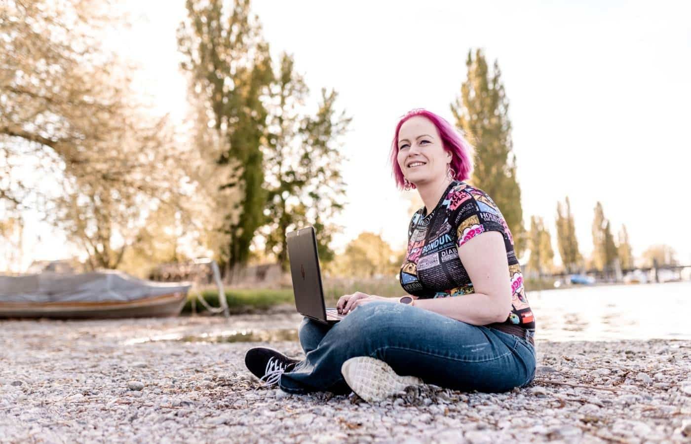 Katja Gersdorf arbeitet mit dem Laptop am Ufer